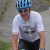 Cyclist wearing a Cigala Cycling branded white technical jersey with Italian flag