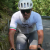 Person wearing a white Cigala Cycling jersey paired with grey Van Rysel bib shorts and a white helmet